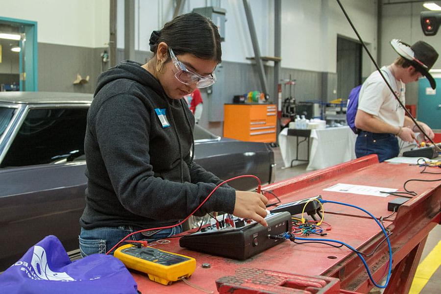 Two 火博体育 students using diagnostic tools in the automotive repair shop