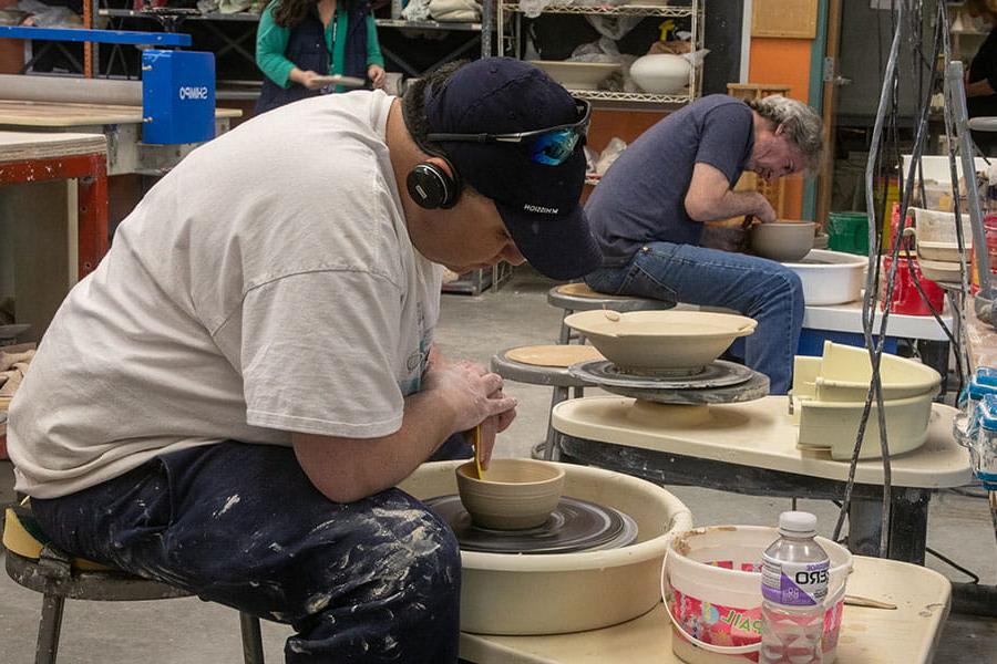 火博体育s students using potter's wheel to create bowls